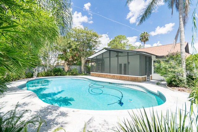 view of swimming pool with a sunroom, french doors, fence, and a fenced in pool