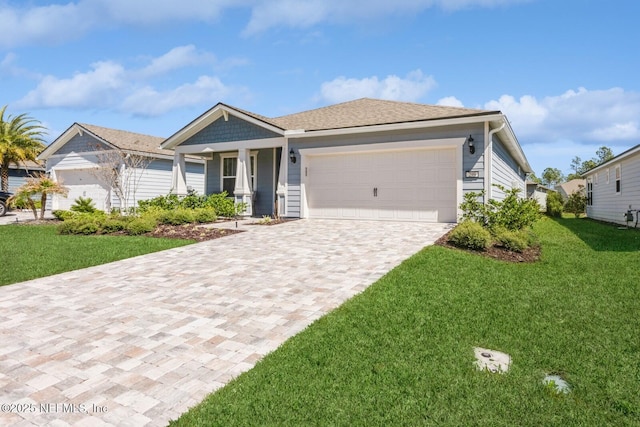 view of front of house featuring a garage, decorative driveway, and a front yard