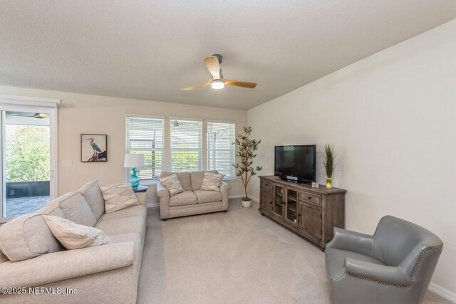 living room with light carpet, plenty of natural light, and a ceiling fan