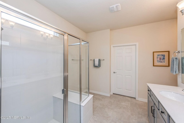 full bathroom featuring a stall shower, visible vents, vanity, and baseboards