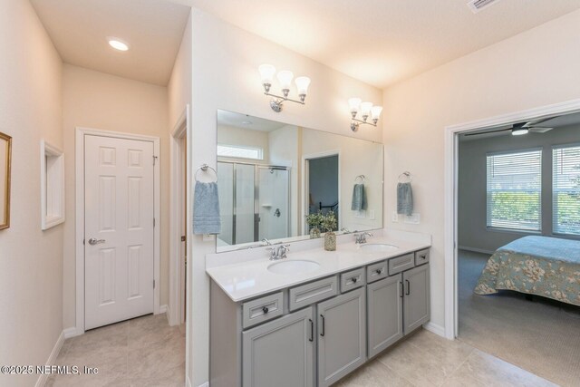 bathroom featuring double vanity, tile patterned floors, a sink, and a shower stall