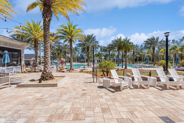 view of property's community with a swimming pool, a patio area, and visible vents