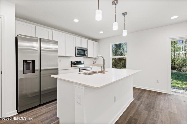 kitchen featuring stainless steel appliances, light countertops, a healthy amount of sunlight, and a sink