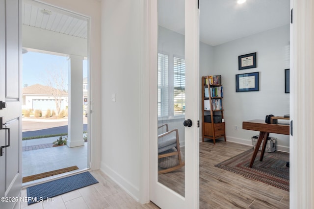 entryway with light wood finished floors and baseboards