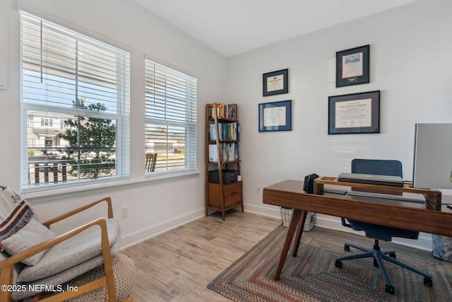 home office with baseboards and light wood finished floors