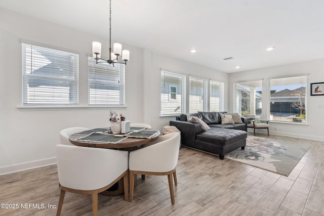 dining area with light wood-style floors, baseboards, a notable chandelier, and recessed lighting