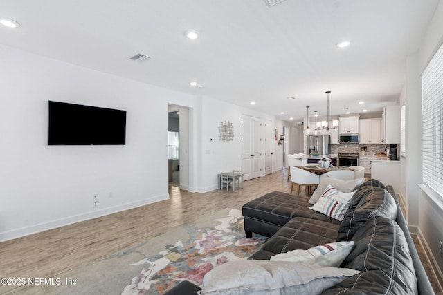 living area with a notable chandelier, recessed lighting, visible vents, baseboards, and light wood-style floors