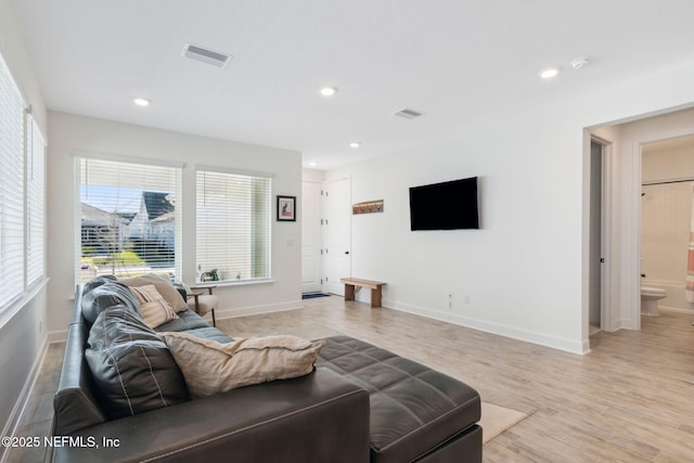 living room with light wood finished floors, visible vents, and recessed lighting