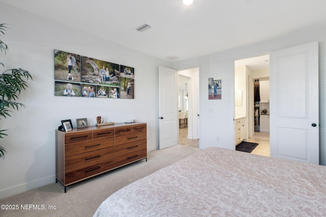 bedroom with ensuite bath, visible vents, baseboards, and light colored carpet