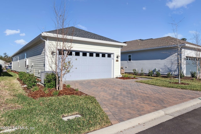 view of front facade featuring a garage and a shingled roof