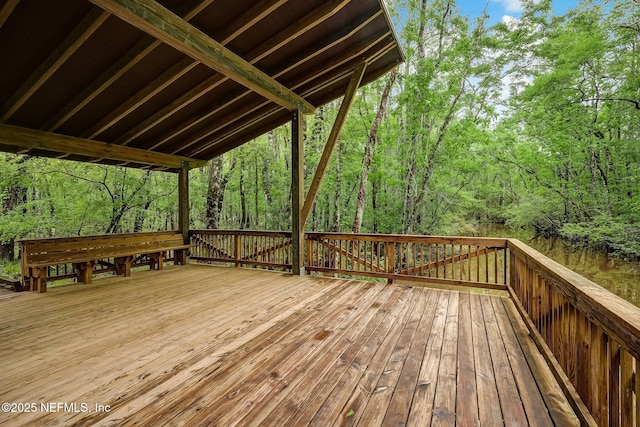 wooden terrace featuring a view of trees