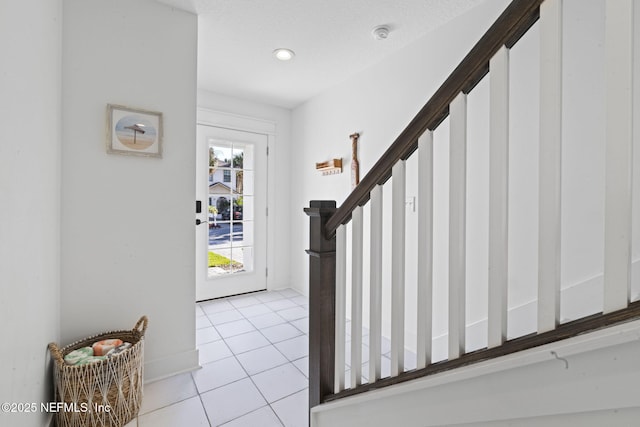 2072 Gail Ave, Jacksonville Beach, FL 32250 - foyer entrance with light tile patterned flooring, stairway, and a textured ceiling