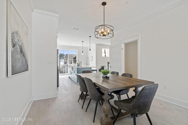 2072 Gail Ave, Jacksonville Beach, FL 32250 - dining area featuring visible vents, light wood-style flooring, baseboards, and ornamental molding