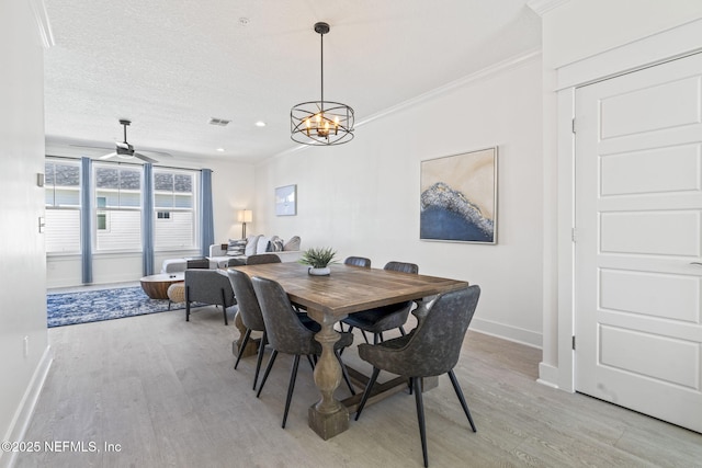 2072 Gail Ave, Jacksonville Beach, FL 32250 - dining room with light wood finished floors, ceiling fan with notable chandelier, baseboards, and ornamental molding