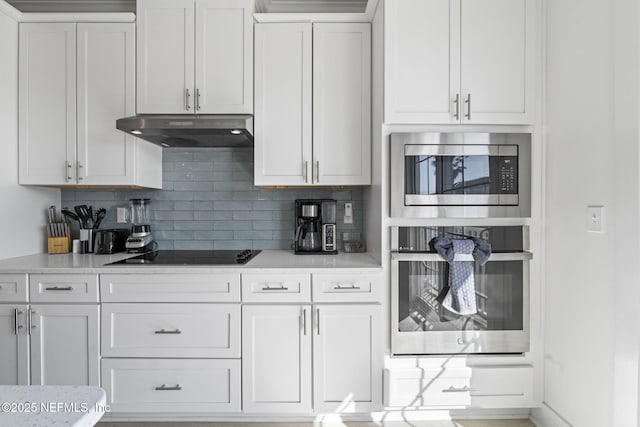 2072 Gail Ave, Jacksonville Beach, FL 32250 - kitchen with under cabinet range hood, decorative backsplash, white cabinetry, and stainless steel appliances