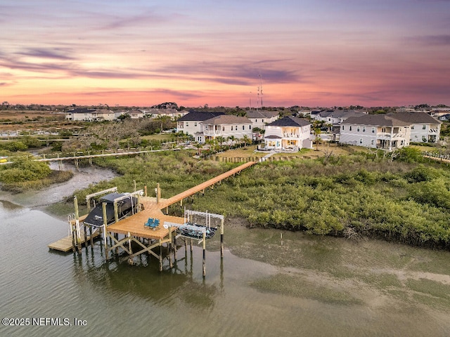 dock area with a residential view, a water view, and boat lift