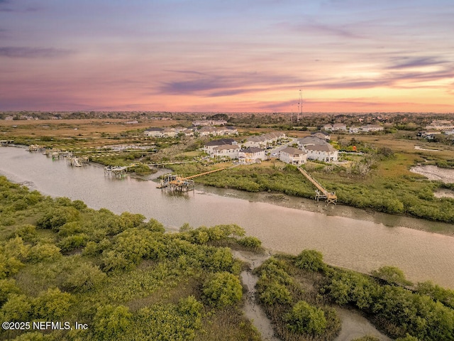 aerial view at dusk featuring a water view