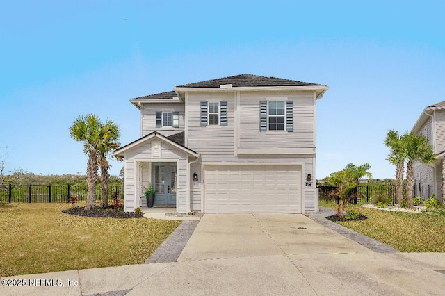 traditional-style home featuring an attached garage, fence, concrete driveway, and a front yard