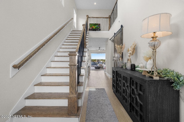 stairs with a high ceiling, baseboards, and recessed lighting