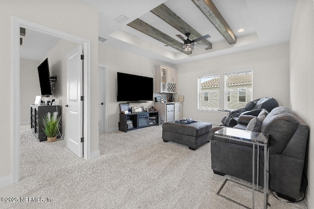 living room featuring visible vents, baseboards, beam ceiling, a tray ceiling, and carpet