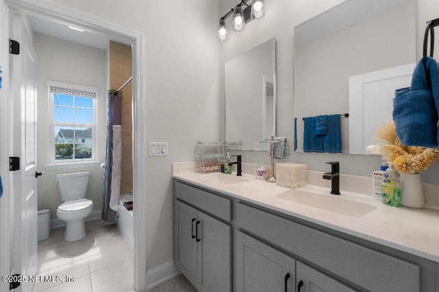 bathroom featuring double vanity, tile patterned flooring, a sink, and toilet