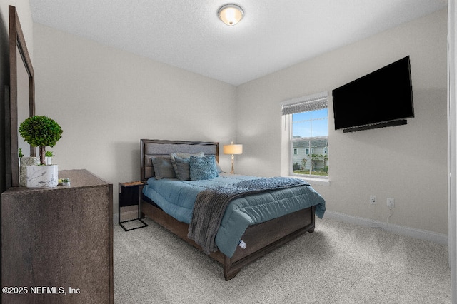 bedroom with baseboards and light colored carpet