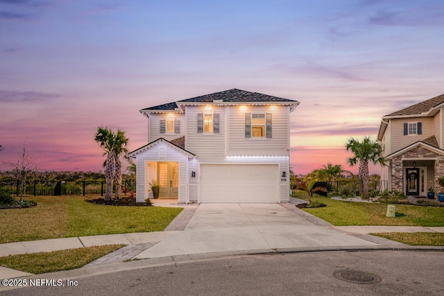 view of front of property featuring driveway, an attached garage, fence, and a front lawn