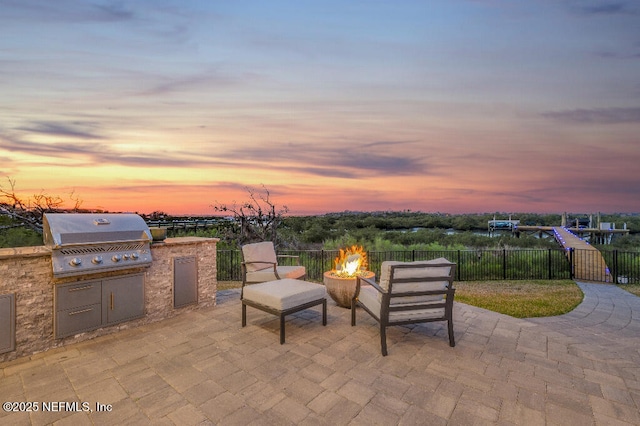 view of patio featuring an outdoor fire pit, area for grilling, a grill, and fence