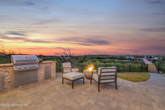 367 Five Island Dr, Saint Augustine, FL 32080 - view of patio featuring fence, a grill, a fire pit, and an outdoor kitchen
