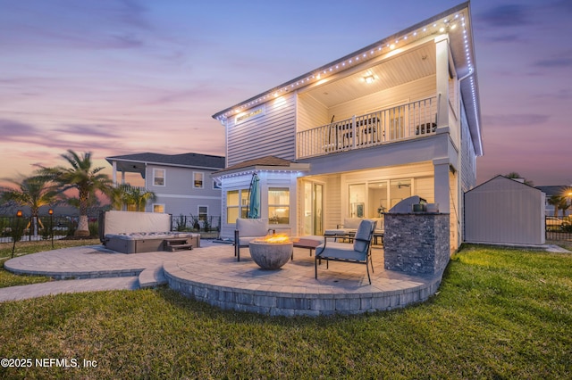 367 Five Island Dr, Saint Augustine, FL 32080 - back of house at dusk featuring an outbuilding, a shed, a patio, a fire pit, and a balcony