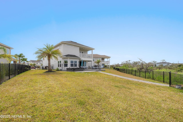 367 Five Island Dr, Saint Augustine, FL 32080 - rear view of house featuring a yard, a balcony, a fenced backyard, and a patio area
