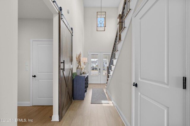 367 Five Island Dr, Saint Augustine, FL 32080 - entrance foyer with plenty of natural light, a barn door, light wood-style flooring, and stairs