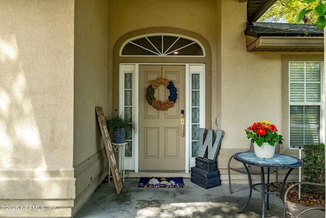 doorway to property featuring stucco siding