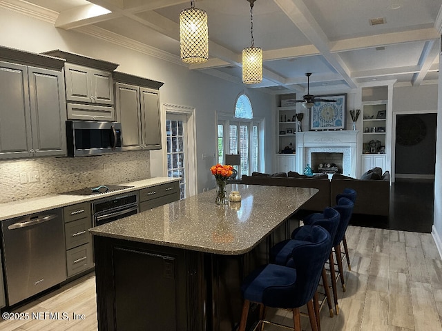 kitchen featuring light wood-style flooring, appliances with stainless steel finishes, and coffered ceiling