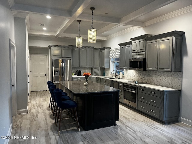 kitchen with light wood-type flooring, tasteful backsplash, appliances with stainless steel finishes, and a kitchen island