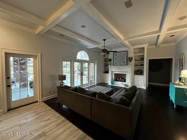 living room featuring a fireplace, wood finished floors, baseboards, and coffered ceiling