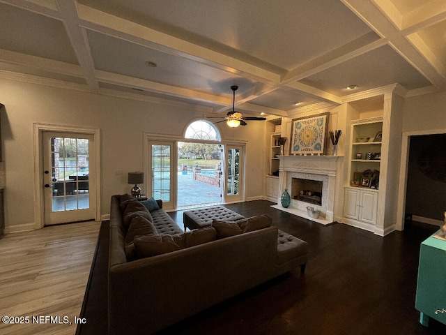 living room with baseboards, a fireplace with flush hearth, coffered ceiling, and wood finished floors