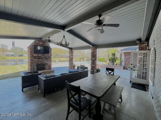 view of patio / terrace featuring outdoor dining space, ceiling fan, and an outdoor fireplace