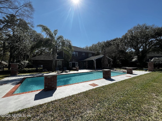 outdoor pool with a lawn and a patio