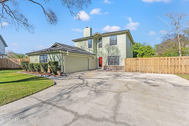 traditional-style house with driveway, a chimney, an attached garage, fence, and a front lawn