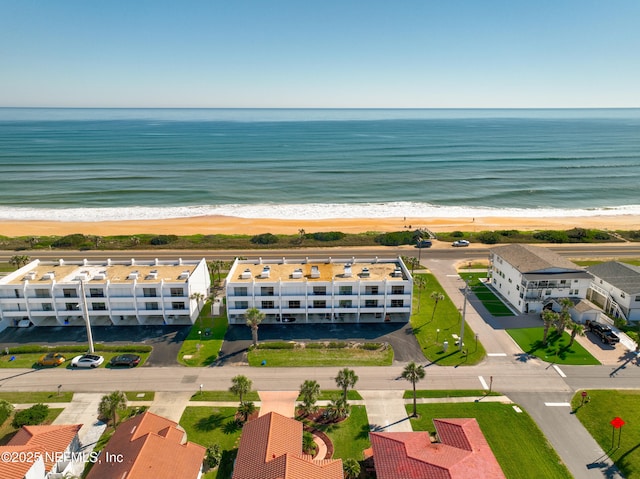 birds eye view of property featuring a beach view and a water view