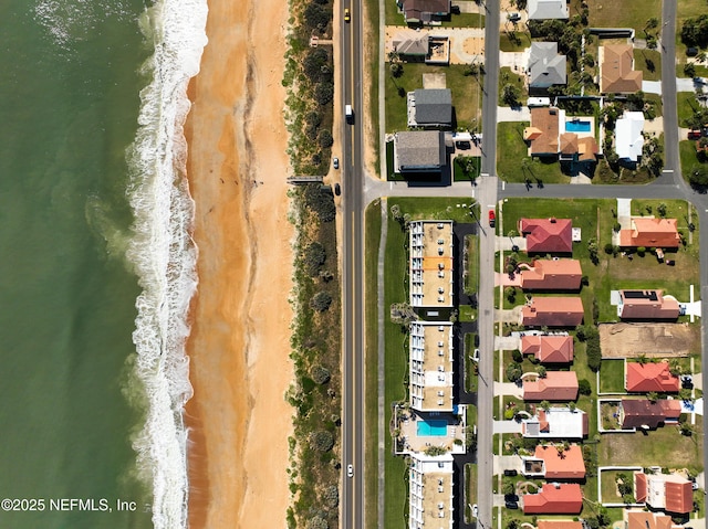 birds eye view of property featuring a water view and a beach view