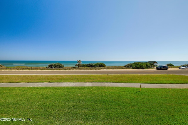 view of home's community featuring a lawn and a water view