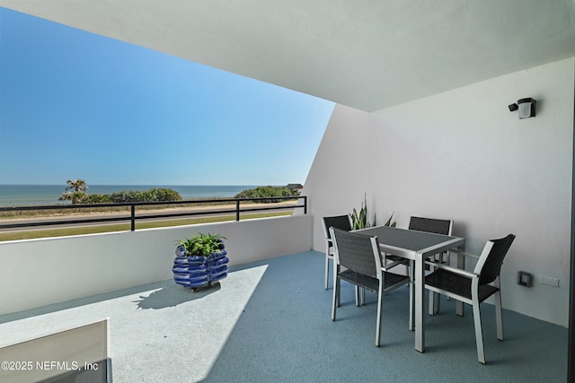 balcony featuring outdoor dining space and a water view