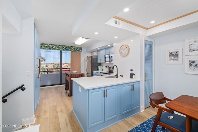 kitchen with blue cabinets, visible vents, appliances with stainless steel finishes, and a sink