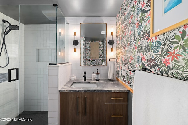 full bathroom with vanity, a shower stall, tile walls, and tasteful backsplash