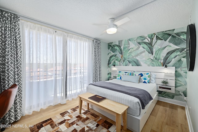 bedroom with baseboards, a textured ceiling, a ceiling fan, and wood finished floors