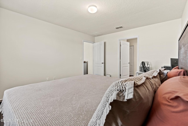 bedroom with visible vents and a textured ceiling