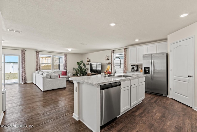 kitchen featuring visible vents, dark wood-type flooring, a sink, appliances with stainless steel finishes, and light countertops