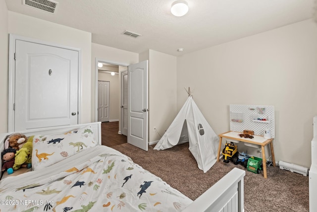 bedroom featuring visible vents, dark colored carpet, and a textured ceiling